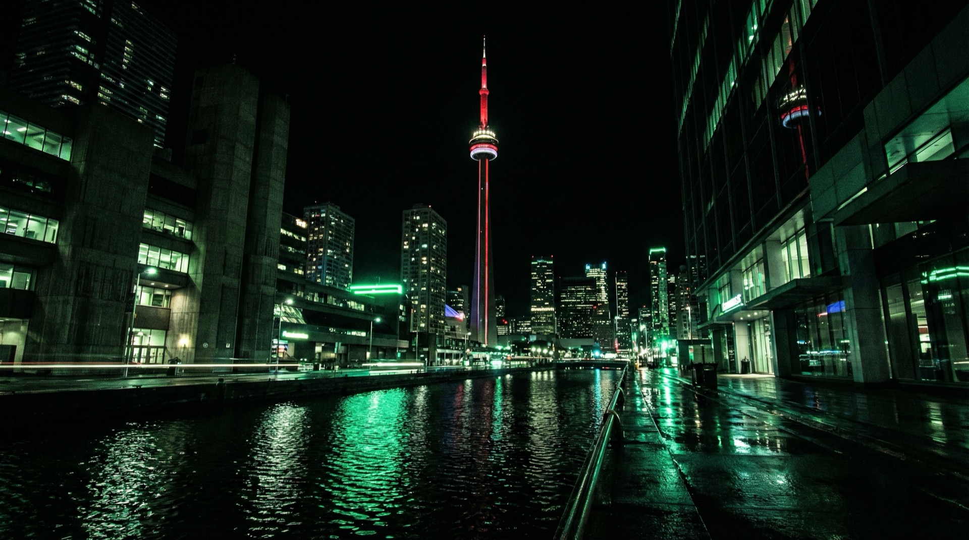 Toronto skyline at night with CN Tower and neon green reflections